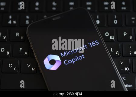KYIV, UKRAINE - MARCH 17, 2024 Microsoft Copilot logo on iPhone display screen and MacBook keyboard. Artificial Intelligence engine Stock Photo