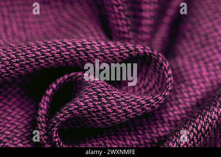 A colorful braided pattern on a purple knit fabric Stock Photo