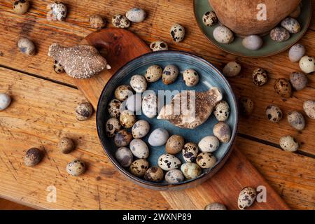 A vibrant display of natural quail eggs, resting on a rustic wooden surface. Stock Photo
