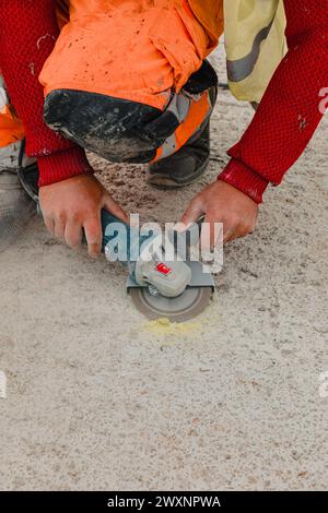 A man grinding concrete floor with power tool Stock Photo