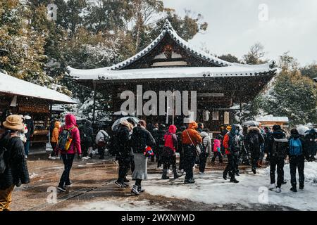 The Worshipers at a a rare snow-covered Buddhist temple at Kinkaku Ji in Kyoto Japan Stock Photo