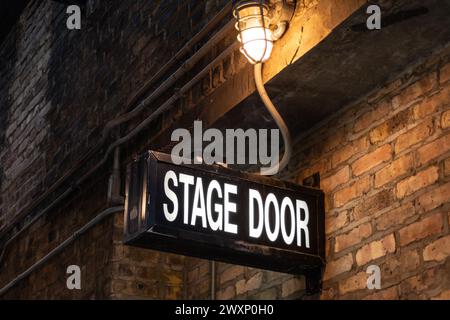 Vintage illuminated stage door sign in a dark and dingy back alley in the city of Chicago, Illinois, USA Stock Photo