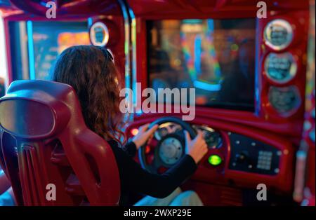 Girl playing racing simulator game in theme park Stock Photo - Alamy