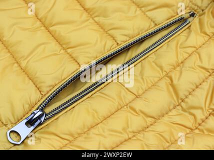 Unzipped metal zipper on the pocket yellow jacket close-up Stock Photo