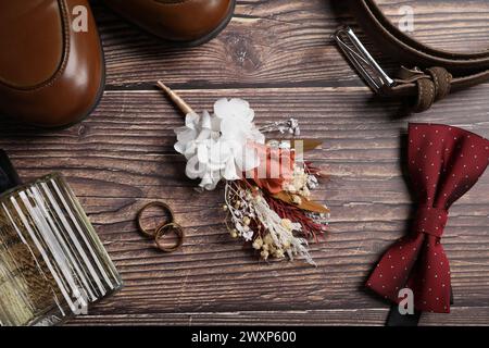 Wedding stuff. Flat lay composition with stylish boutonniere on wooden background Stock Photo