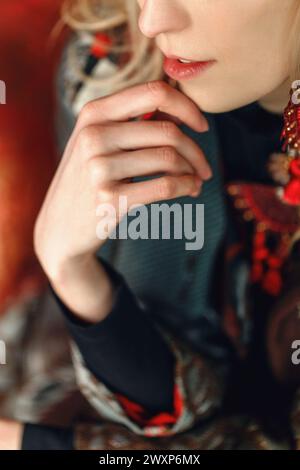 A detailed view of a person wearing a necklace, capturing the intricate design of the jewelry piece and its reflection on the persons attire. Stock Photo