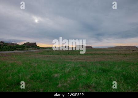 Beautiful icelandic landscape in early morning. Green grass, yellow sunrise, clouds and road in the distance. Very beautiful scenery around  hvalnesvi Stock Photo