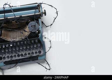 Vintage typewriter with barbed wire on white background. Printing ban concept Stock Photo