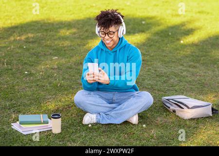 Student sitting outside using smartphone Stock Photo