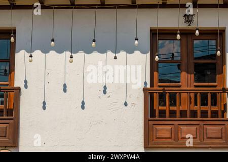 Some hanging bulbs cast their shadow on a white wall in the afternoon, in the colonial town of Villa de Leyva in central Colombia. Stock Photo