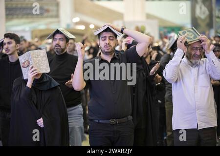 Tehran, Tehran, Iran. 1st Apr, 2024. Shiite worshipers place copies of the Quran on their heads during the holy Islamic month of Ramadan, in Tehran, Iran, Sunday, April 01, 2024. (Credit Image: © Sobhan Farajvan/Pacific Press via ZUMA Press Wire) EDITORIAL USAGE ONLY! Not for Commercial USAGE! Stock Photo