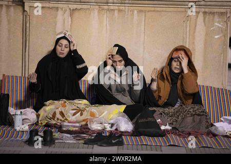 Tehran, Tehran, Iran. 1st Apr, 2024. Shiite worshipers place copies of the Quran on their heads during the holy Islamic month of Ramadan, in Tehran, Iran, Sunday, April 01, 2024. (Credit Image: © Sobhan Farajvan/Pacific Press via ZUMA Press Wire) EDITORIAL USAGE ONLY! Not for Commercial USAGE! Stock Photo