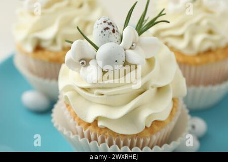 Tasty Easter cupcakes with vanilla cream on table, closeup Stock Photo