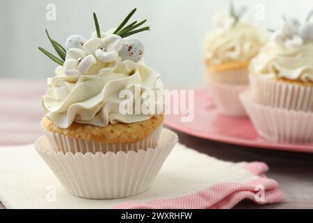 Tasty Easter cupcakes with vanilla cream on table Stock Photo