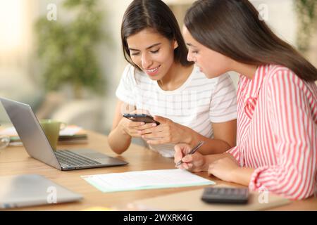 Two tele workers taking photo of contract sitting at home Stock Photo