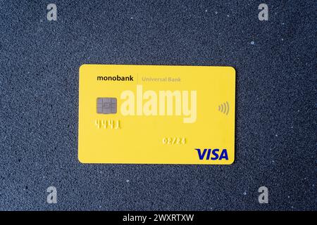 Credit card of the Ukrainian bank Monobank from Universal Bank. Yellow Visa card with chip. Ukraine, Kyiv - March 17, 2023. Stock Photo