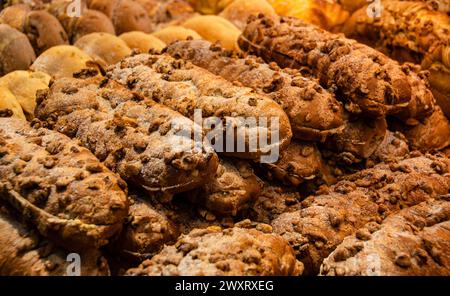 A closeup shot of a variety of breads and pastries displayed on a bakery shelf Stock Photo