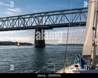 Sailboat sailing towards Old Little Belt Bridge connecting Jutland and Funen in Southern Denmark, Denmark Stock Photo