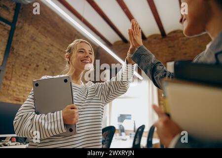 Successful business people giving each other a high five in a meeting Stock Photo
