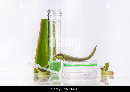 Aloe vera gel or extract with laboratory equipment, glassware. Organic green cosmetics, self care, beauty care concept on white background copy space Stock Photo