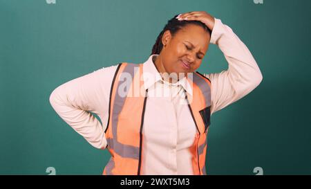 Young Black manager experiencing backache pain on construction site Stock Photo