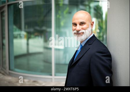 Mature bald stylish business man portrait with a white beard outdoor Stock Photo