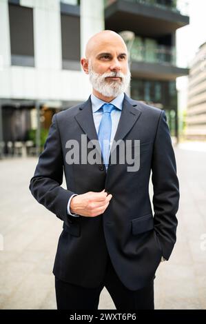 Mature bald stylish business man portrait with a white beard outdoor Stock Photo