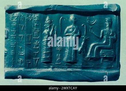 Babylonian cylinder seal impression of a seated god and a worshipper, Sumeria Stock Photo