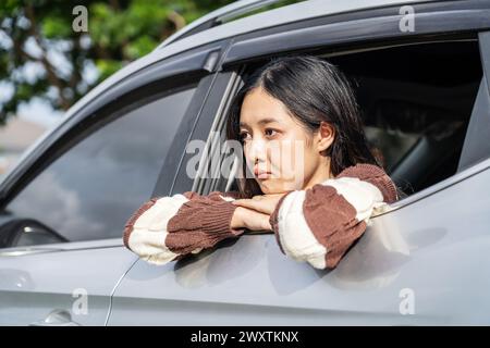 A woman sadly gazing out of a car window Stock Photo