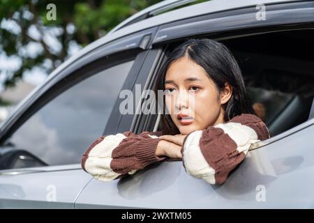 A woman sadly gazing out of a car window Stock Photo
