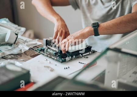 Component Connection : A close-up of hands meticulously assembling a desktop's motherboard, symbolizing the confluence of technology and manual Stock Photo