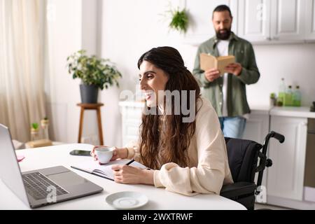 joyous disabled woman in wheelchair having video call next to her reading handsome husband at home Stock Photo