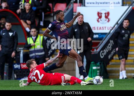 Peterborough United's Kwame Poku and Leyton Orient's Ethan Galbraith during the Sky Bet League One match at the Gaughan Group Stadium, London. Picture date: Monday April 1, 2024. Stock Photo