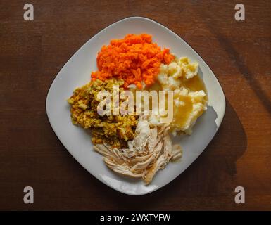 Turkey dinner on a white plate with potatoes, gravy, stuffing and carrots Stock Photo