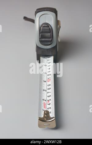 steel retractable measuring tape with flexible metal strip used industries like construction, carpentry, sewing and crafting isolated gray background Stock Photo