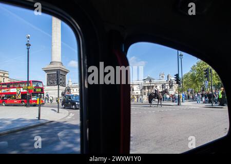 A double decker bus driving down a city street in London, England, viewed through a taxi window. Stock Photo