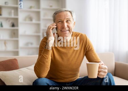 Happy senior talking on phone with coffee mug Stock Photo