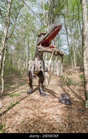 A spinosaurus in wildlife forest It's a dinosaur replica in nature Stock Photo