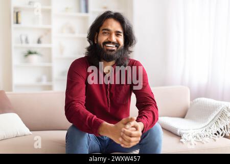Smiling man sitting on couch in a home Stock Photo