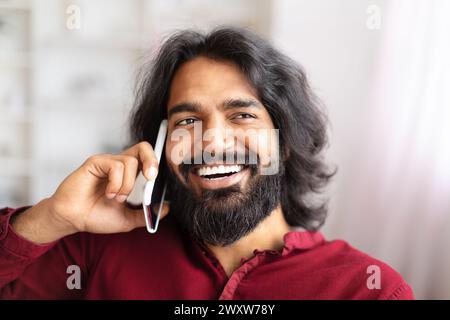 Man smiling while talking on phone at home Stock Photo