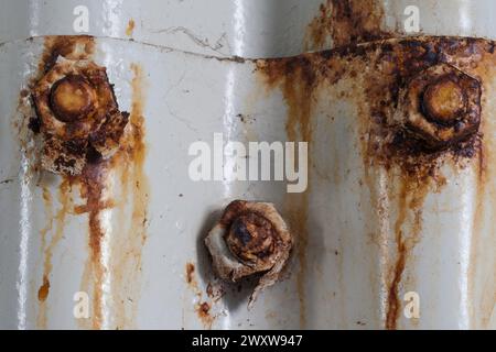 Rusting screws holding corrugated sheets together testify to transience and connection. Stock Photo
