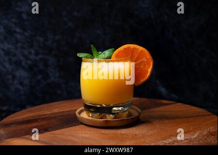 Whiskey Sour. hiskey and orange juice cocktail on an brown sugar rimmed glass with ice orange slice and mint. Stock Photo