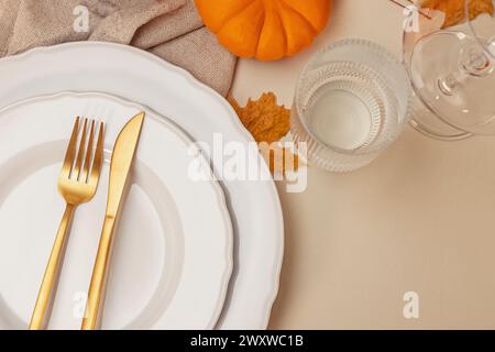 Elegant fall table setting. Table decorated for autumn dinner with white plates and golden cutlery, top view Stock Photo