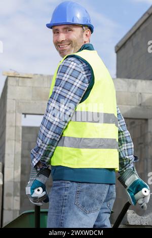 builder carrying blocks on a wheelbarrow Stock Photo