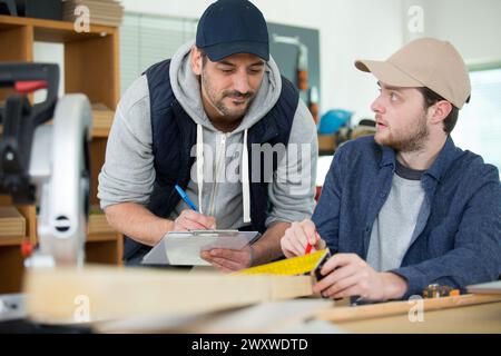carpenter with apprentice in training period Stock Photo