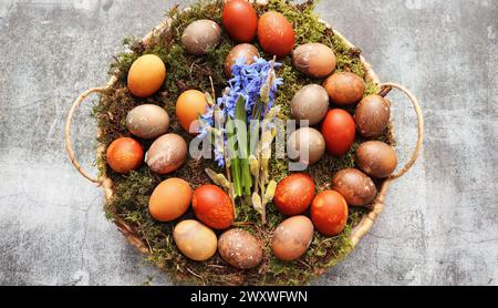 Stylish Easter table setting. Natural egg on wicker tray. Easter table decoration . Stock Photo