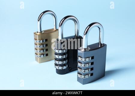 Steel combination padlocks on light blue background, closeup Stock Photo