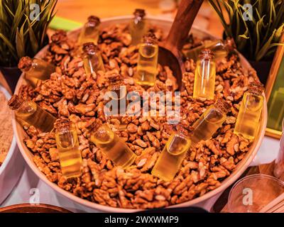 Walnut oil in glass of bottle, whole big peeled walnut kernel without shell. Oil and nuts background. Super food healthy concept Stock Photo