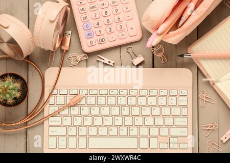 Modern tablet external keyboard, different stationery and devices in pink color on wooden background Stock Photo