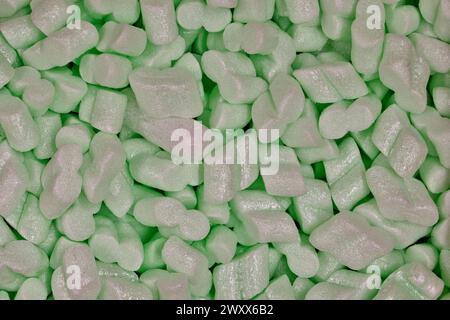 Green packing foam peanuts Styrofoam popcorn packaging noodles material closeup, Polystyrene cushioning protection shipping merchandise. Stock Photo